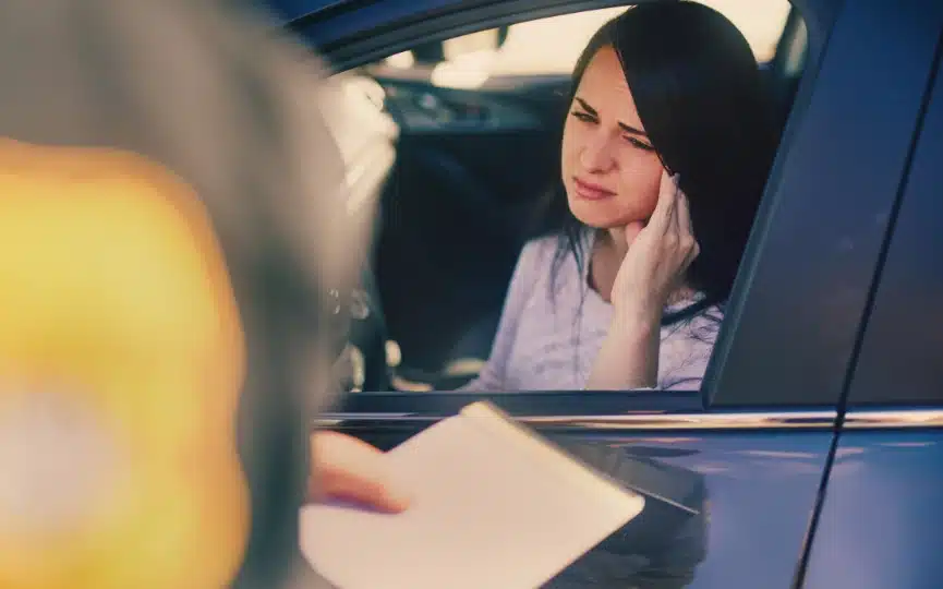 A woman in her car at a traffic stop with a police officer who may need a DUI criminal defense lawyer in Carrollton, Georgia